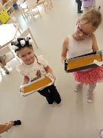 Holčičky nesou těsto, dýňový chlebík, paní kuchařce k upečení.