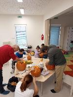 Rodiče při práci, dlabání a vyřezávání dýní.